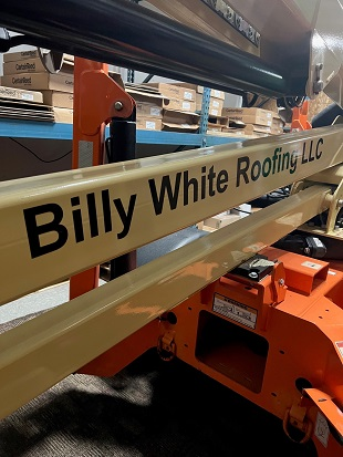 Black letters that say Billy White Roofing LLC printed on equipment